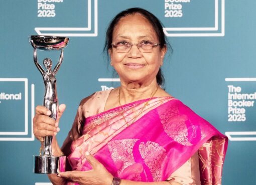 بانو وهي تقف على منصة التتويج في حفل جائزة البوكر 2025 بلندن، تمسك بالدرع